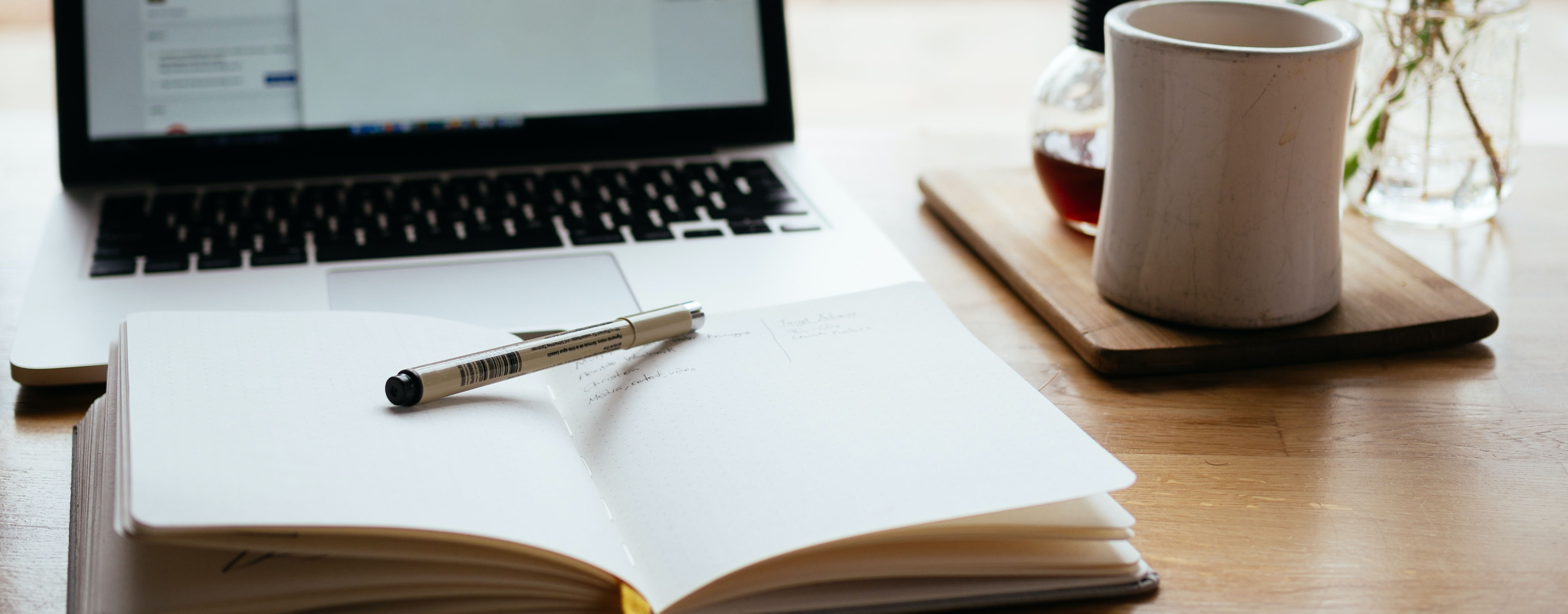 A notebook and computer. This post goes through 11 ways to practice writing in a foreign language.